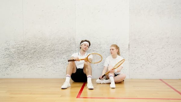 What are the key factors in preventing overuse injuries in professional squash players?